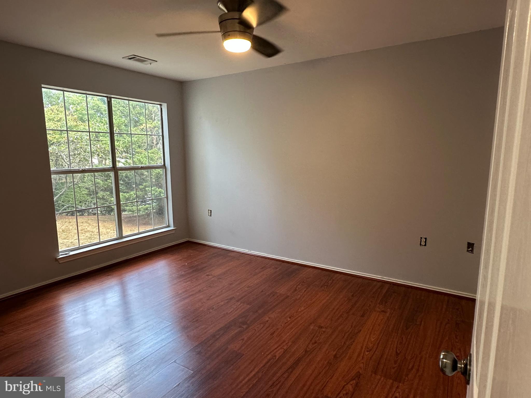 20950 Timber Ridge Terrace, Unit 201 Ashburn, VA 20147 - Photo 14 of 20 a view of an empty room with wooden floor and a window