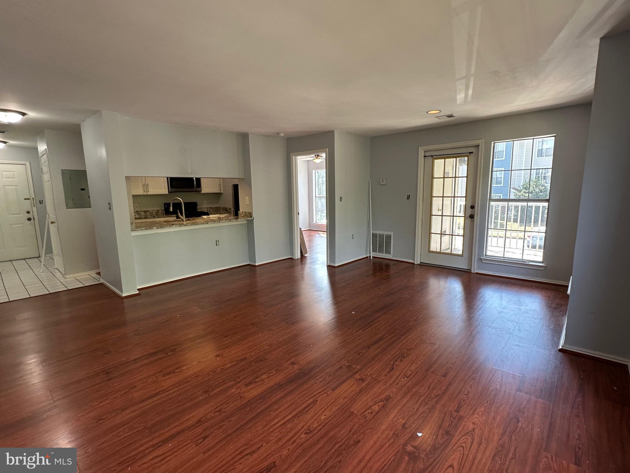 20950 Timber Ridge Terrace, Unit 201 Ashburn, VA 20147 - Photo 6 of 20 a view of a kitchen with a stove wooden floor and a window