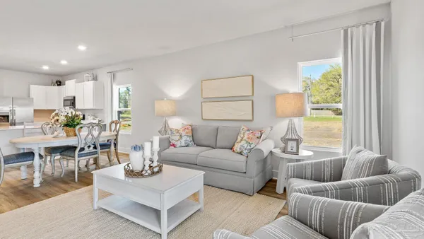 a living room with furniture and view of kitchen