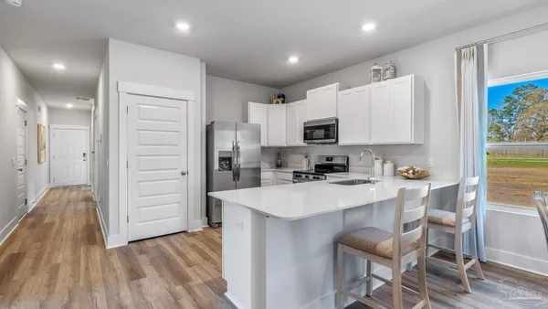 a kitchen with kitchen island granite countertop white cabinets and stainless steel appliances