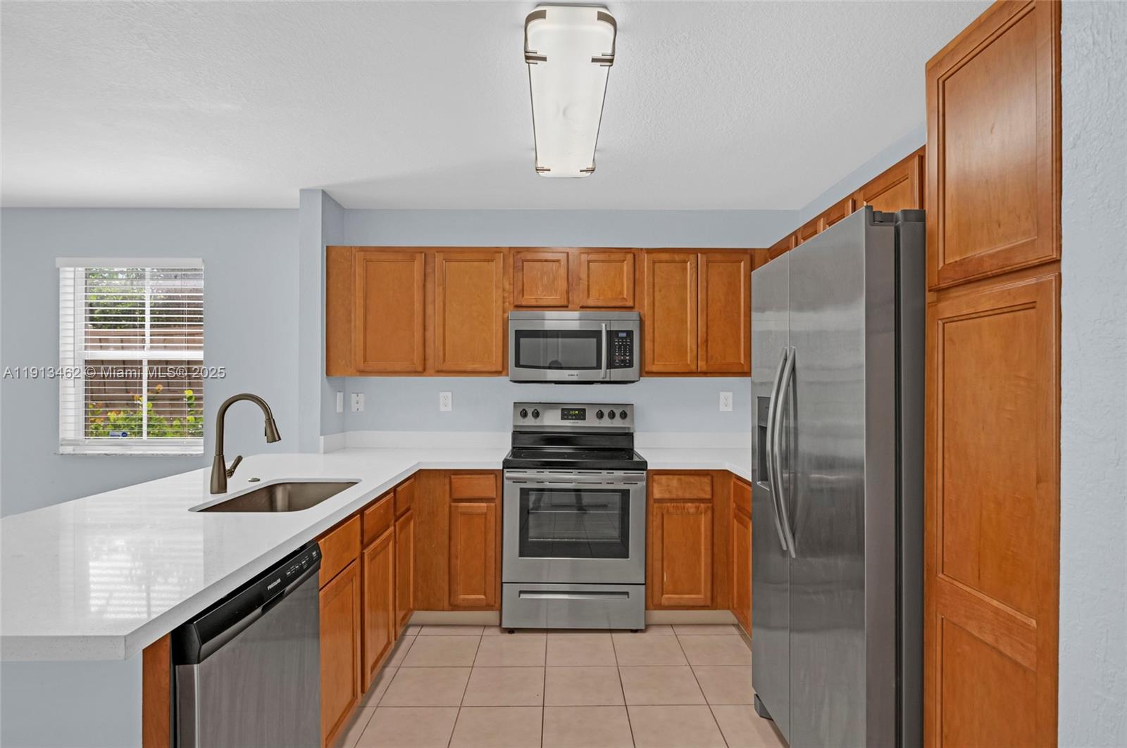3197 Southwest 128th Way, Unit 135 Miramar, FL 33027 - Photo 12 of 35 a kitchen with stainless steel appliances granite countertop a refrigerator and a sink