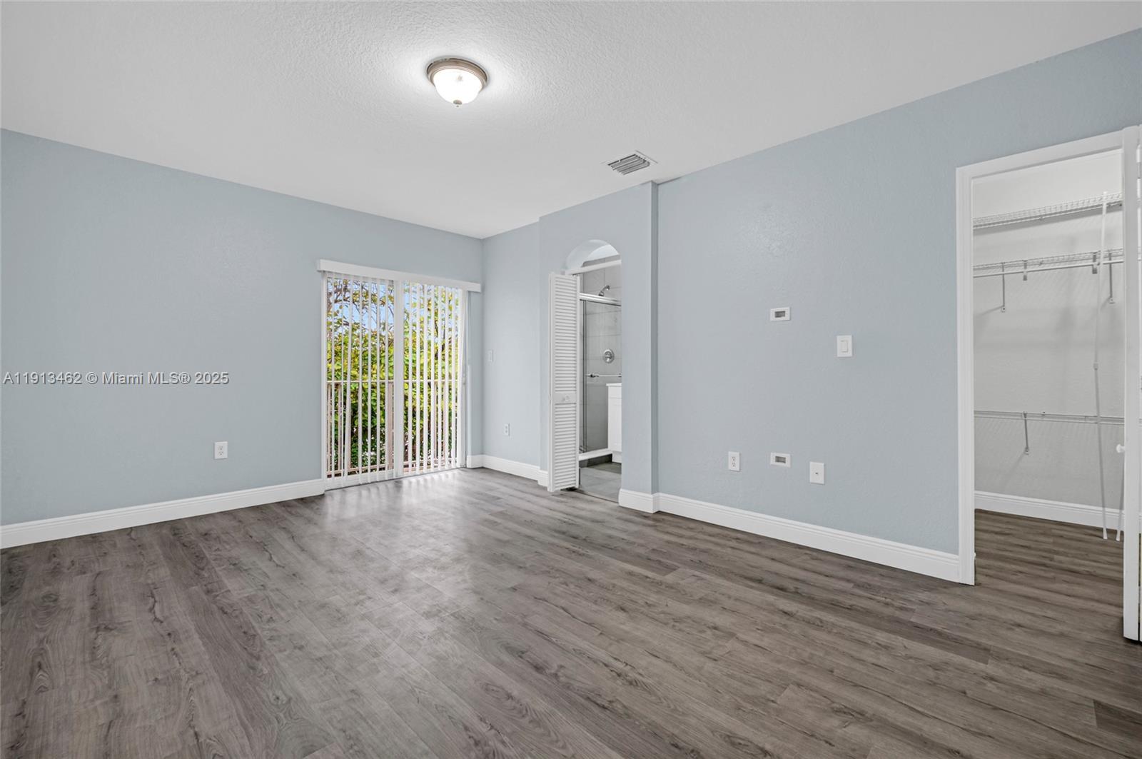 3197 Southwest 128th Way, Unit 135 Miramar, FL 33027 - Photo 19 of 35 an empty room with wooden floor and windows