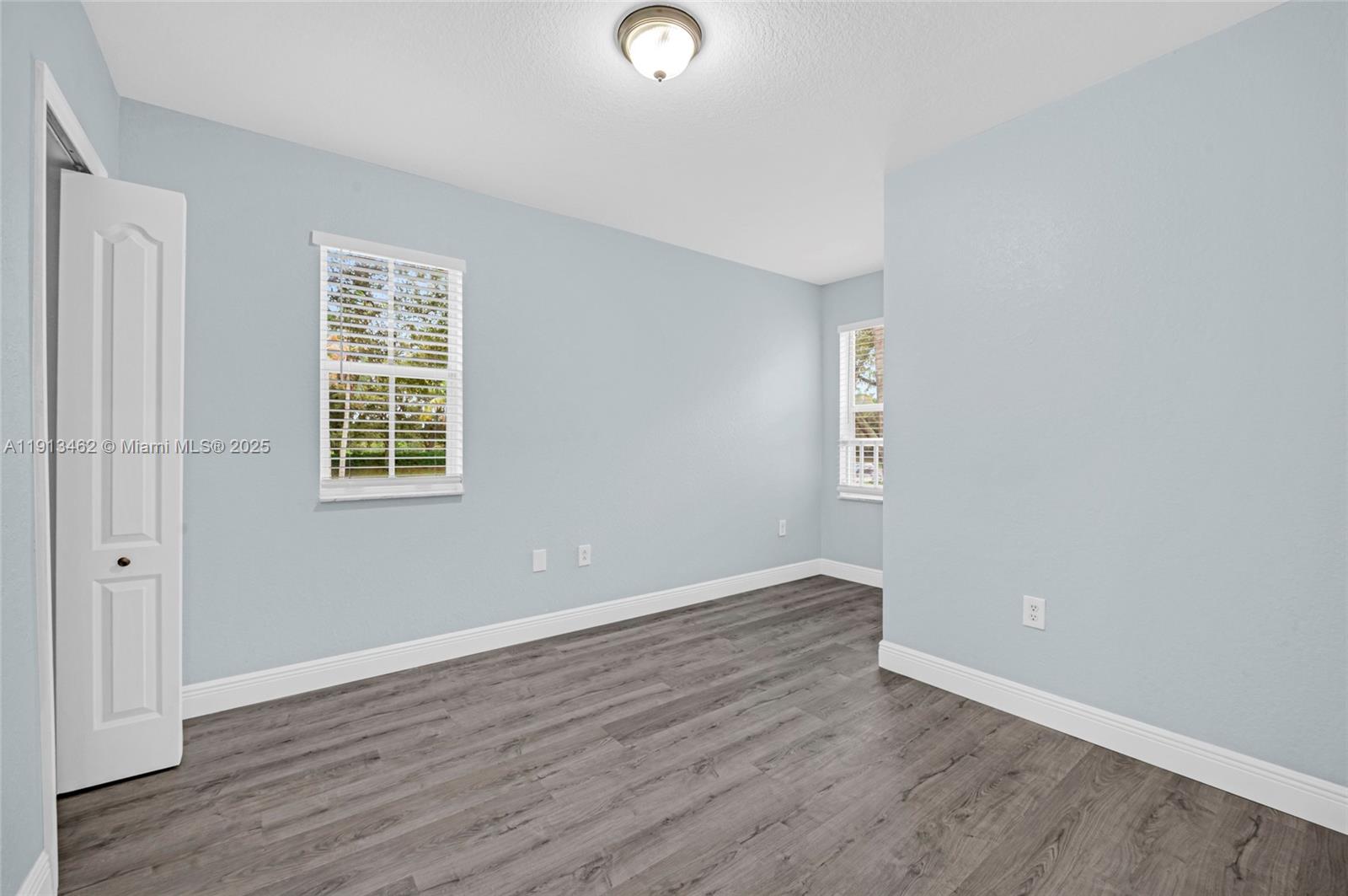 3197 Southwest 128th Way, Unit 135 Miramar, FL 33027 - Photo 23 of 35 an empty room with wooden floor and windows