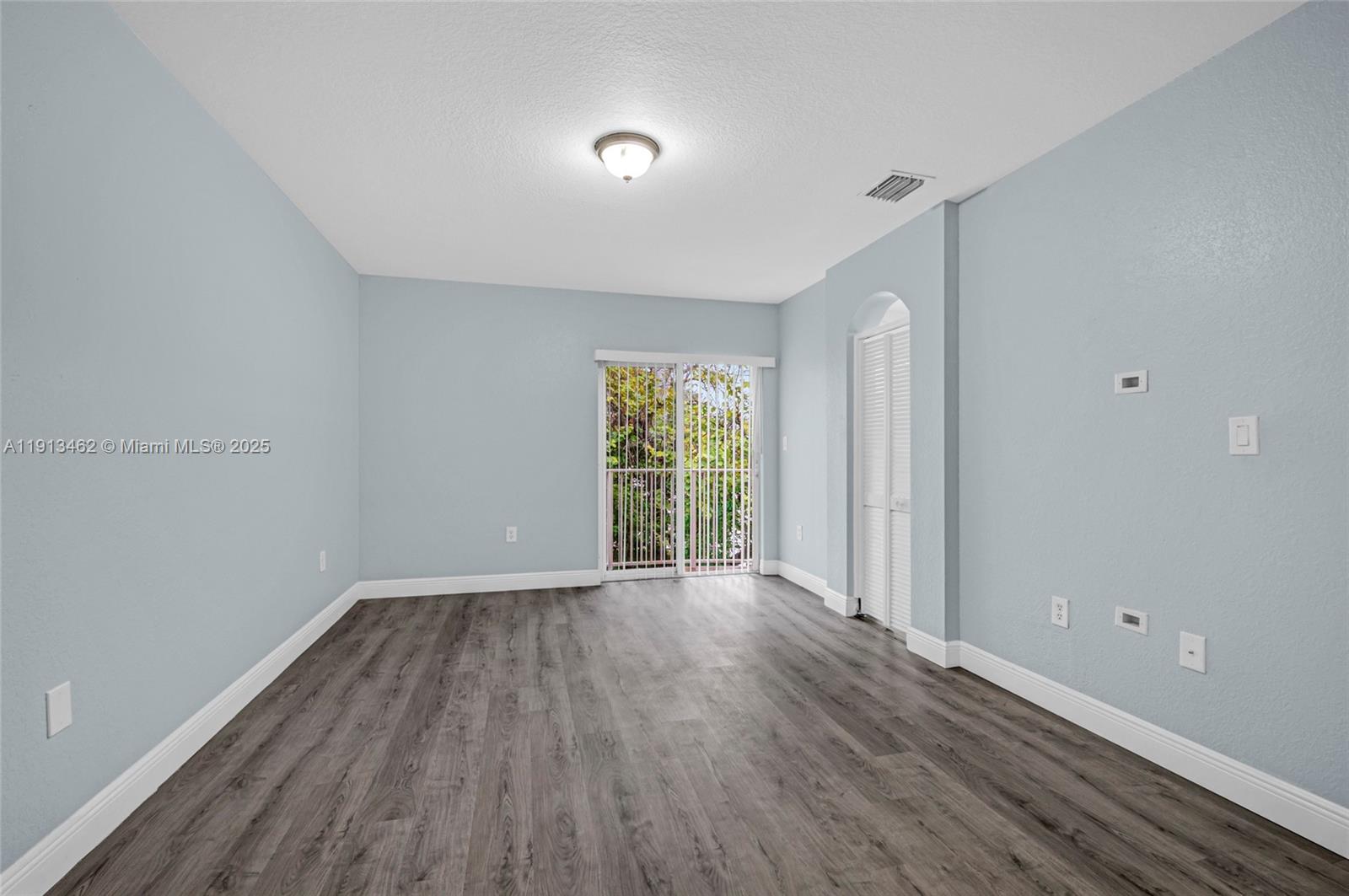 3197 Southwest 128th Way, Unit 135 Miramar, FL 33027 - Photo 35 of 35 a view of an empty room with wooden floor and a window