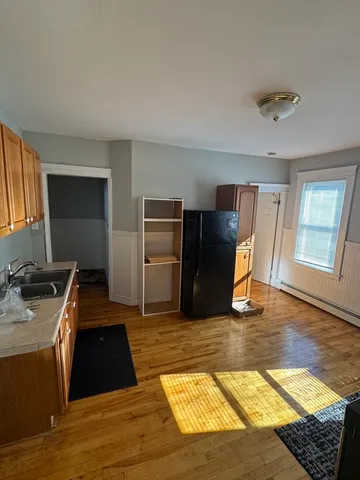 a kitchen with granite countertop stainless steel appliances a stove top oven a sink and a refrigerator