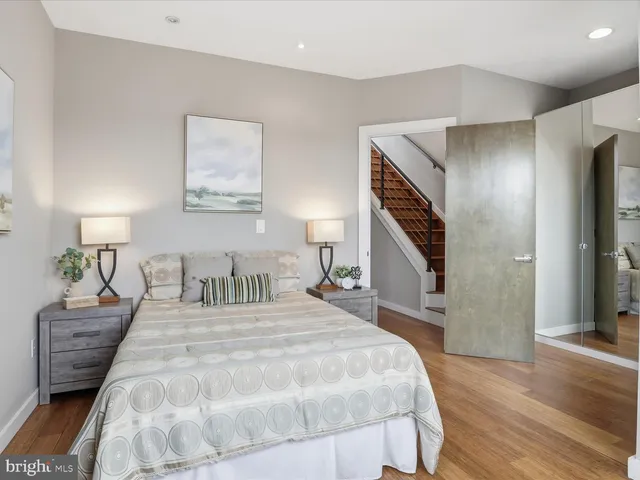 a bedroom with a bed and a flat tv screen on a dresser