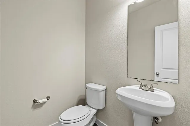 a bathroom with a sink a toilet and mirror