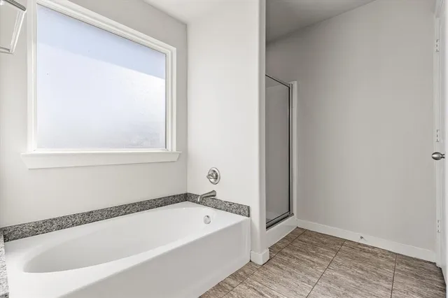 a bathroom with bathtub and a window