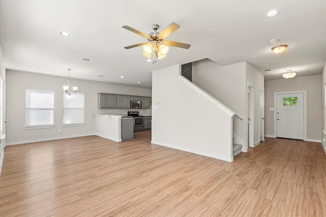 a view of a kitchen with wooden floor and a ceiling fan
