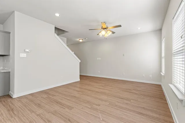 an empty room with wooden floor and window