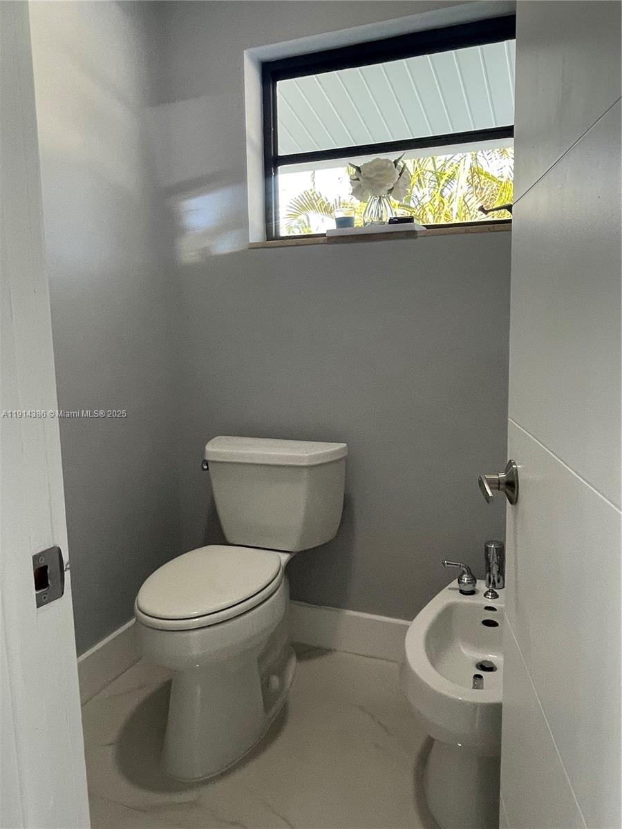 7521 Southwest 56th Street Miami, FL 33155 - Photo 24 of 34 a bathroom with a toilet sink and mirror