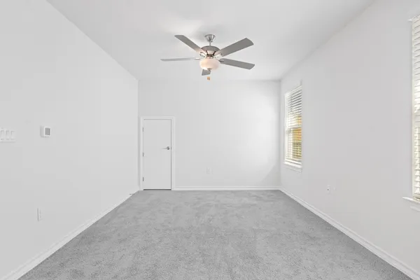 an empty room with a window and a fan