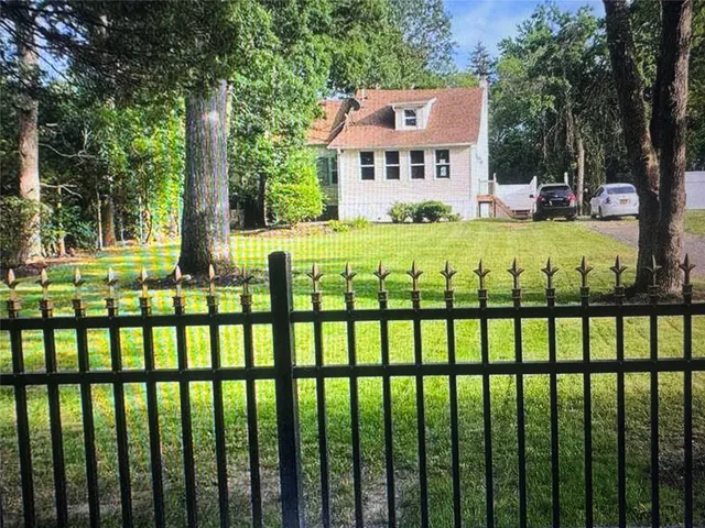 a view of a white building with a garden
