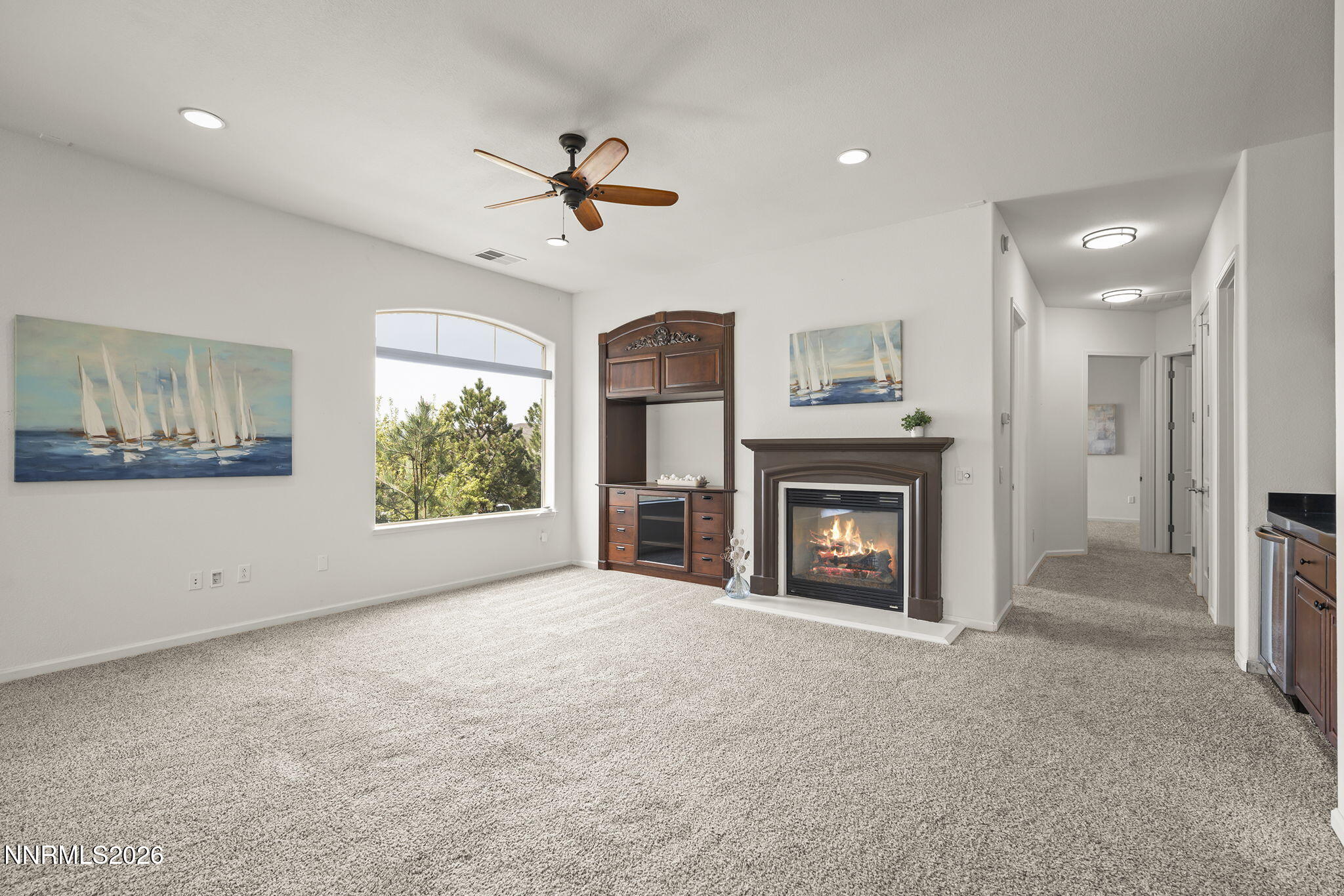 9900 Wilbur May Parkway, Unit 304 Reno, NV 89521 - Photo 8 of 47 a view of a livingroom with a fireplace a ceiling fan and windows