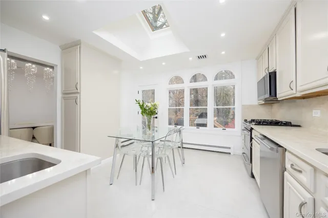 a view of a kitchen with granite countertop a white cabinets and wooden floor