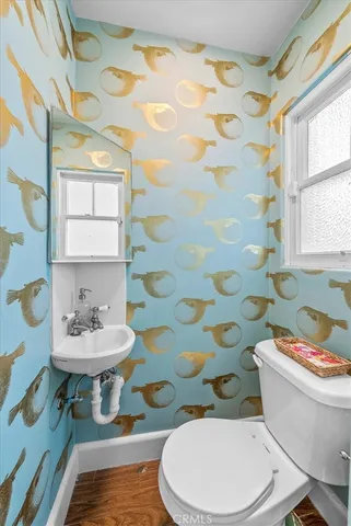 a bathroom with a sink a toilet a mirror and shower curtain