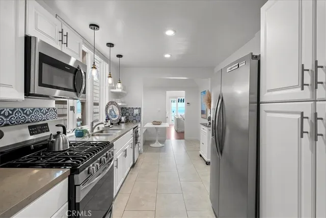 a large kitchen with stainless steel appliances granite countertop a stove a refrigerator and a microwave