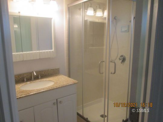 227 South Springside Street Ridgecrest, CA 93555 - Photo 13 of 22 a bathroom with a granite countertop sink mirror and shower