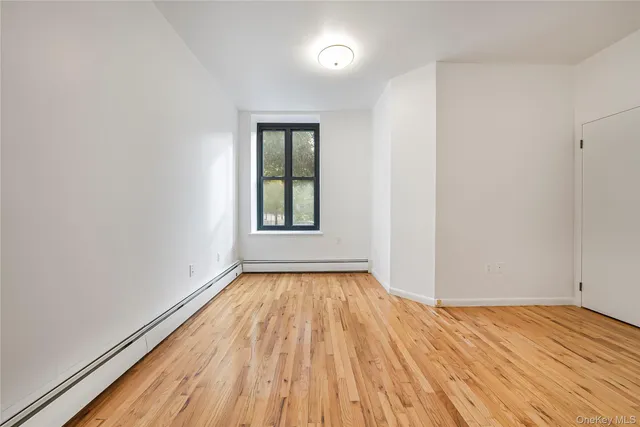wooden floor in an empty room with a window