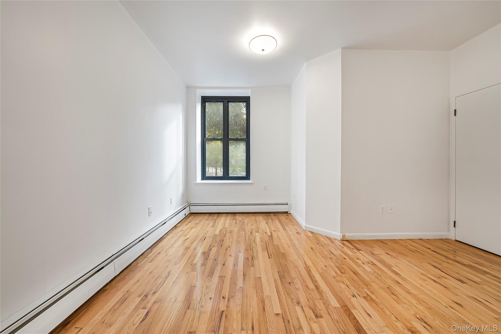 17 East 131st Street, Unit 1A Manhattan, NY 10037 - Photo 8 of 14 wooden floor in an empty room with a window