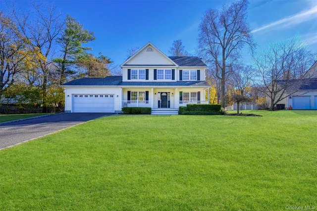 a front view of a house with garden and trees