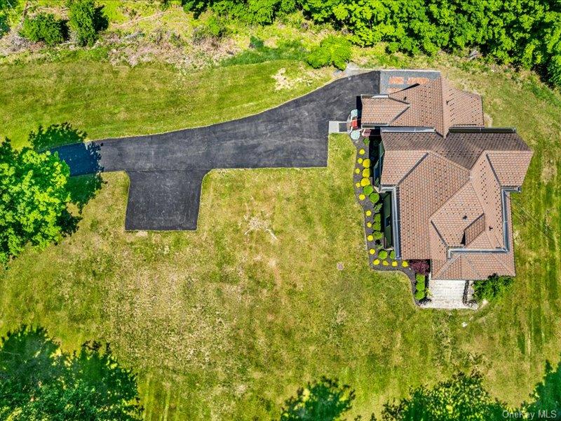 an aerial view of a house with swimming pool and large trees