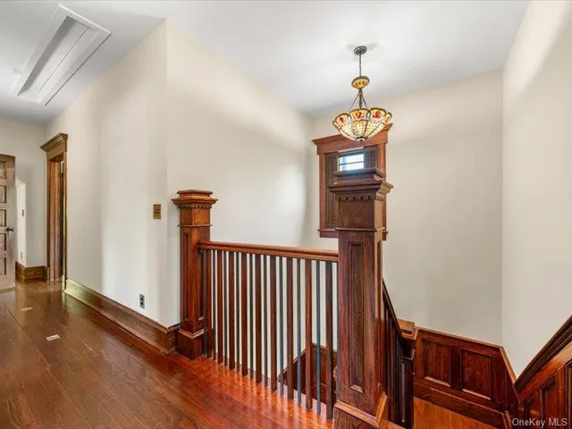 a view of a hallway with wooden floor and staircase