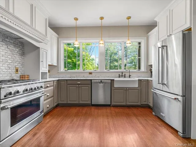 a kitchen with a sink appliances wooden floor and window