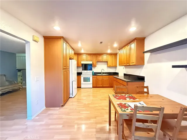 a kitchen with stainless steel appliances kitchen island granite countertop a refrigerator and a stove top oven