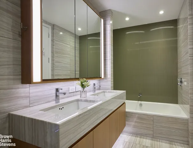 a bathroom with a double vanity sink mirror and shower