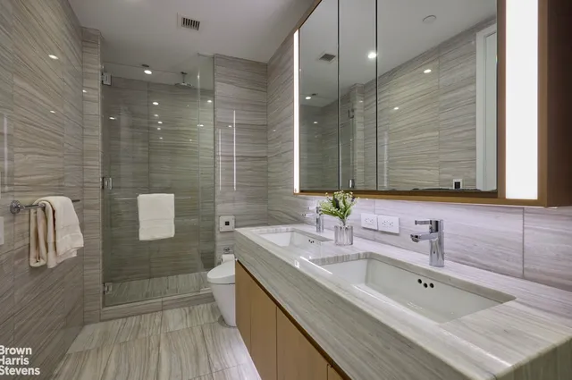 a bathroom with a double vanity sink mirror and shower