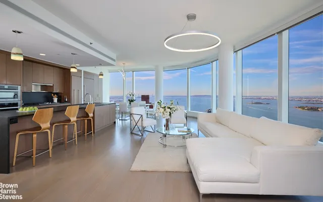 a living room with furniture a kitchen view and a dining table