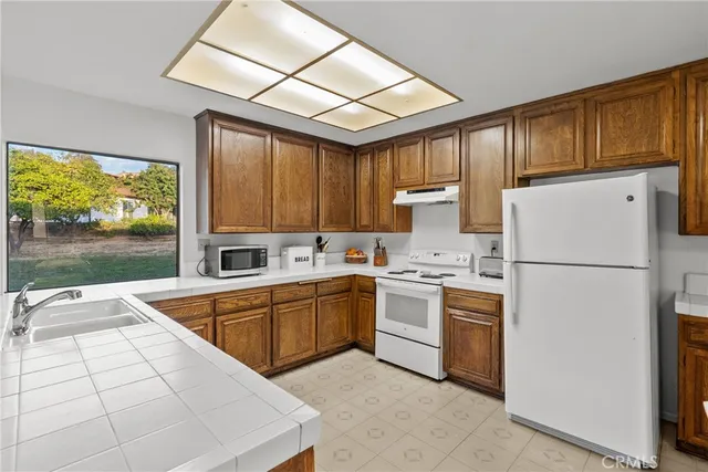 a kitchen with a refrigerator a stove top oven and a large window