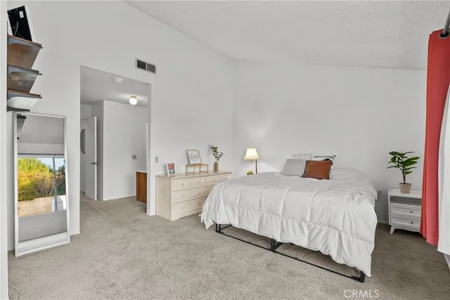 a bedroom with a bed and a view of kitchen