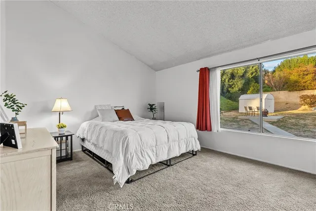 a spacious bedroom with a bed and a large window