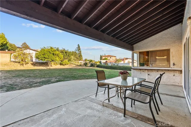 a patio with table and chairs and potted plants