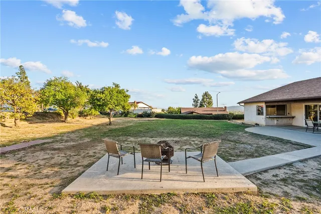 a view of a house with backyard and sitting area