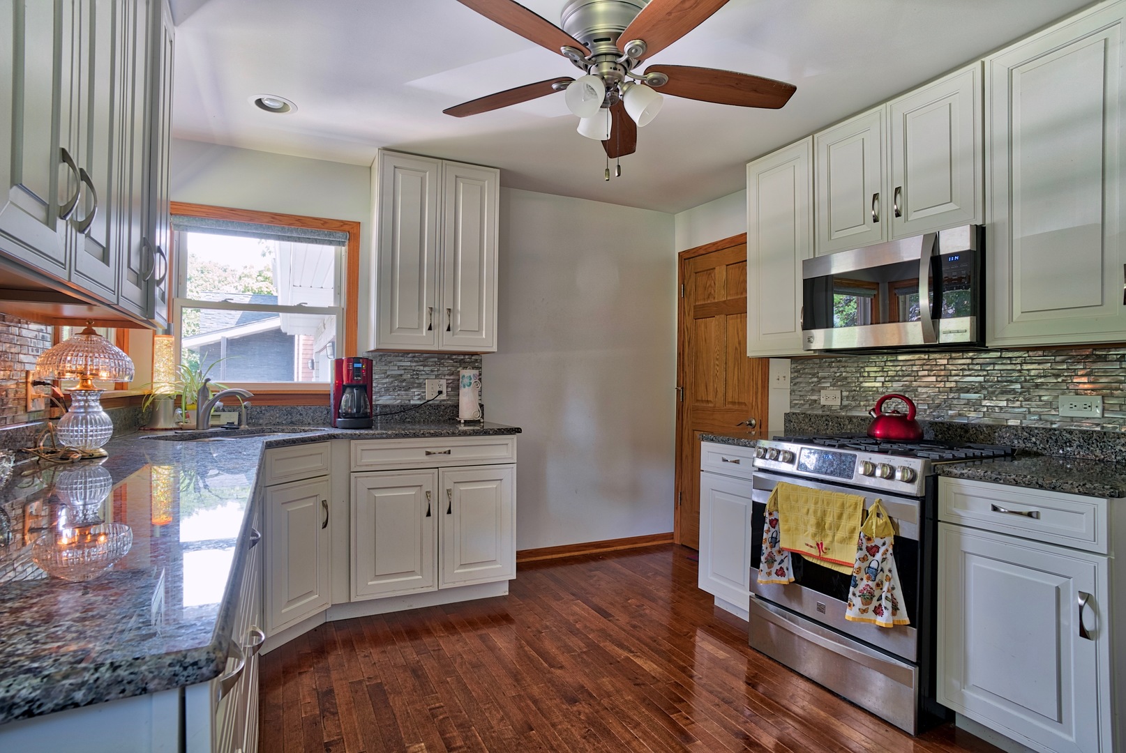 S703 Winfield Road Wheaton, IL 60189 - Photo 4 of 17 a kitchen with stainless steel appliances granite countertop wooden cabinets a stove a sink and dishwasher with wooden floor
