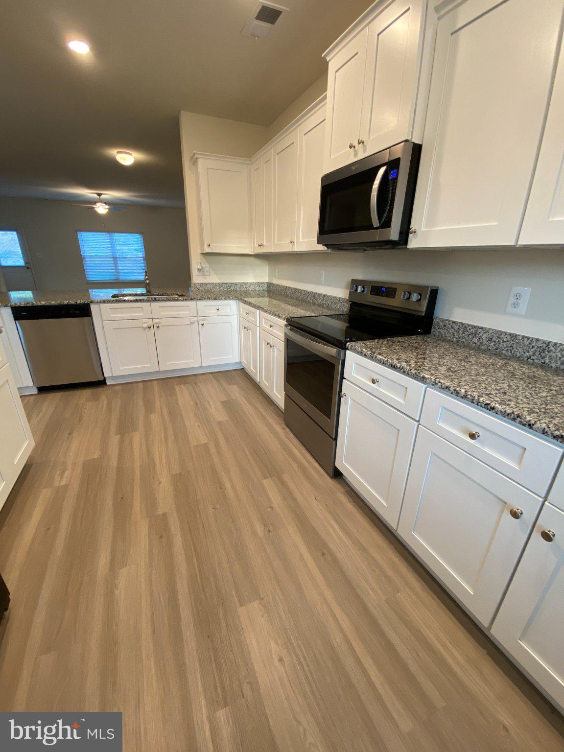 697 Rivanna Run Falling Waters, WV 25419 - Photo 6 of 44 a kitchen with stainless steel appliances a stove a sink and white cabinets