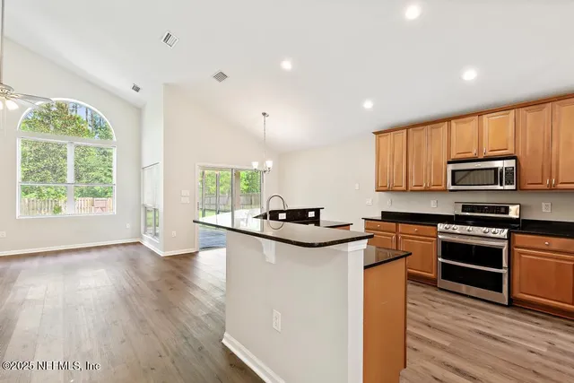 a kitchen with stainless steel appliances granite countertop a stove a sink dishwasher and a refrigerator