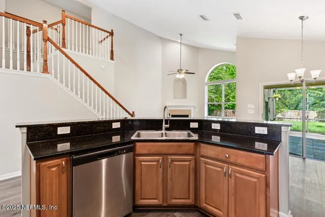 a kitchen with stainless steel appliances granite countertop a stove a sink dishwasher a refrigerator with wooden floor