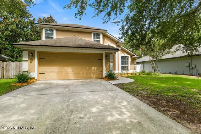 a front view of a house with a yard and garage