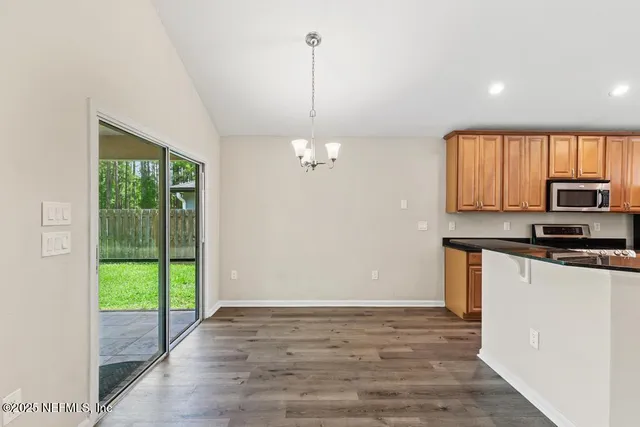 an empty room with wooden floor a fireplace and a window