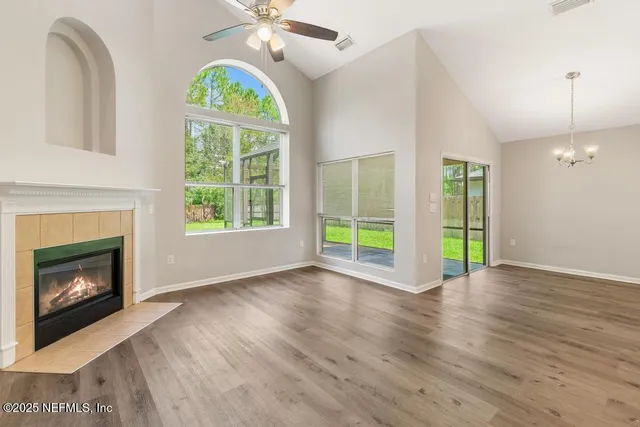 an empty room with wooden floor cabinet and windows
