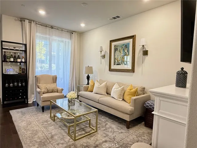a living room with furniture a flat screen tv and a window