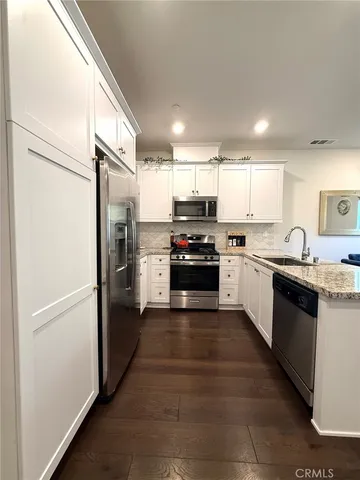 a large kitchen with cabinets and stainless steel appliances