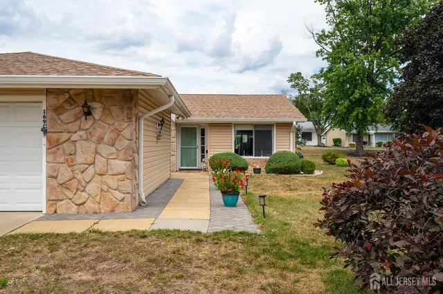 a view of a house with backyard and sitting area