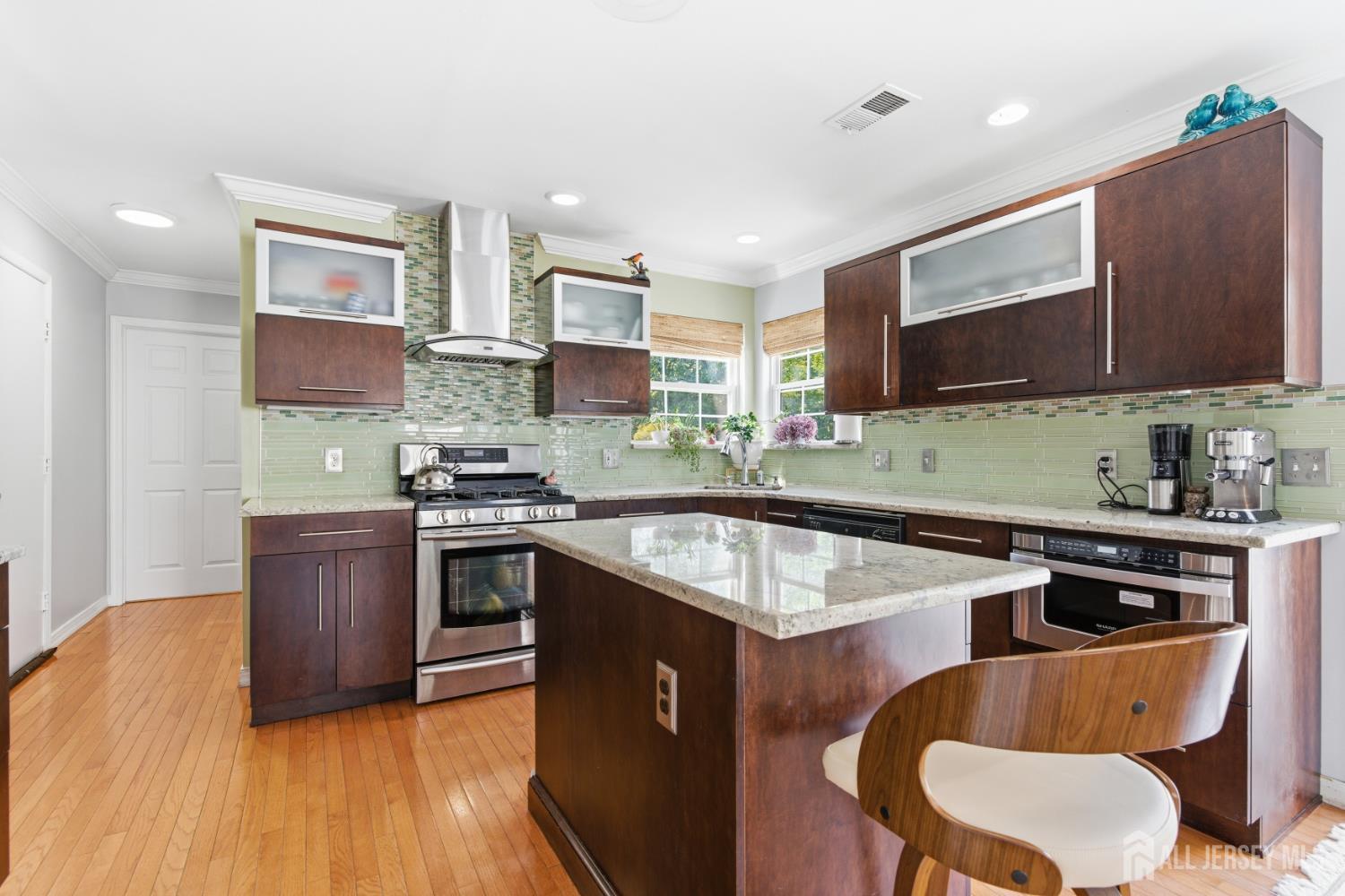 26 Alexis Lane Edison, NJ 08820 - Photo 12 of 39 a kitchen with stainless steel appliances granite countertop a sink a stove a refrigerator a microwave oven with white cabinets and wooden floor