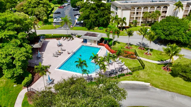 a view of a swimming pool with lawn chairs and a big yard
