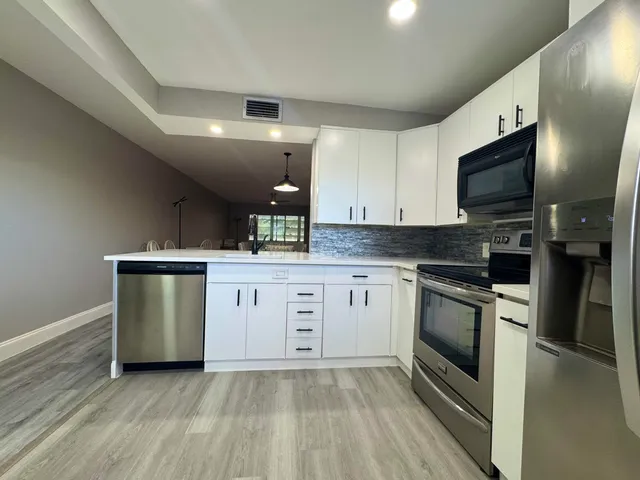 a kitchen with granite countertop a sink and stainless steel appliances